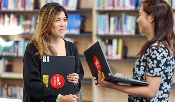 two female international students in library