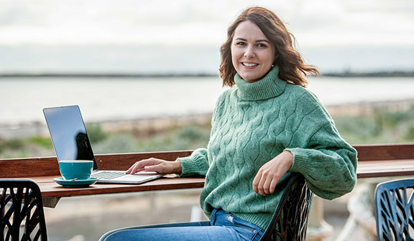 Female student Tamara Woodley using a laptop outside